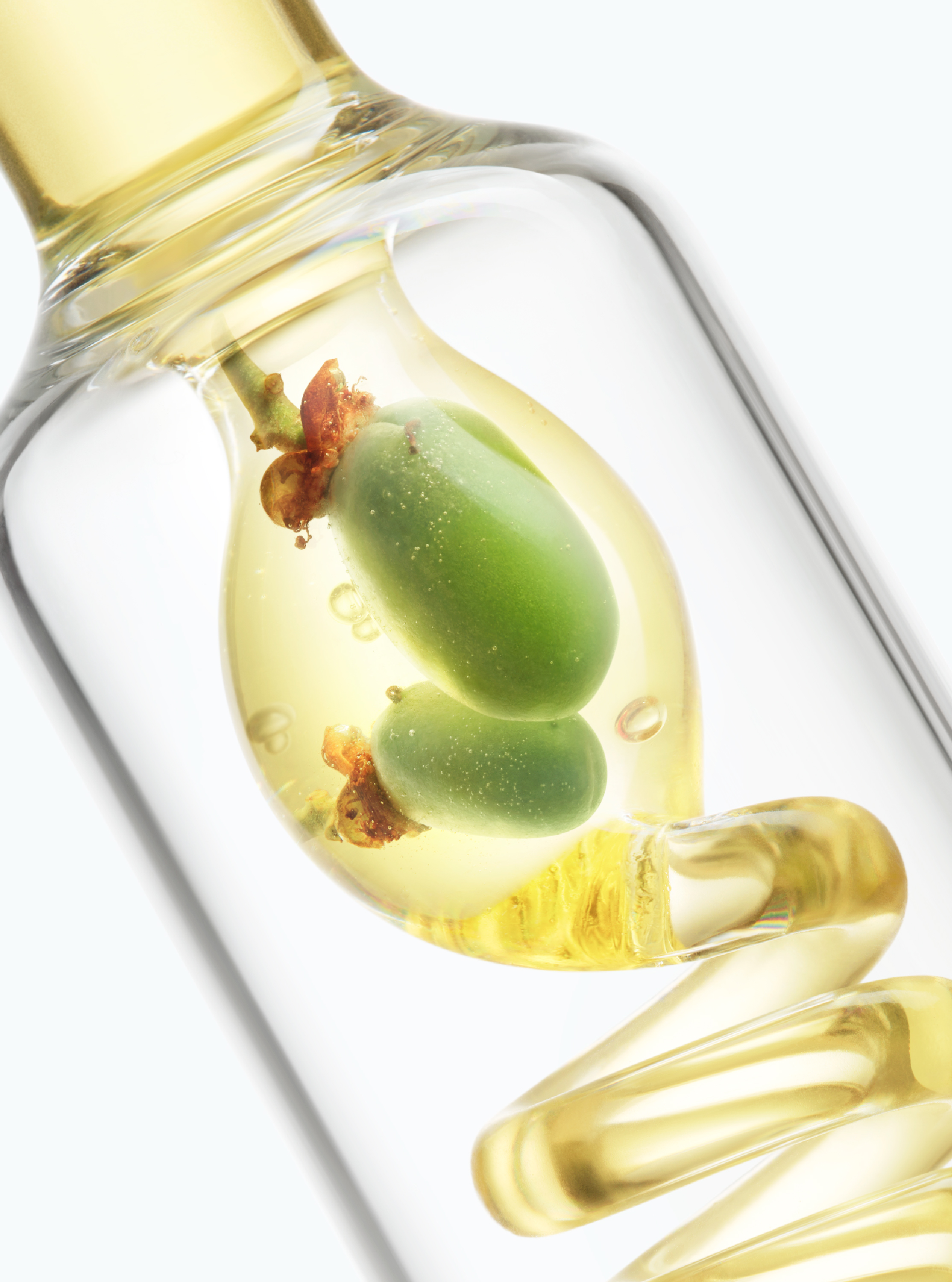 Green botanical fruits and golden liquid in a transparent glass vessel, representing botanical active research